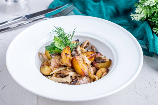 istock Fried potatoes with mushrooms on a white bowl 1393150786