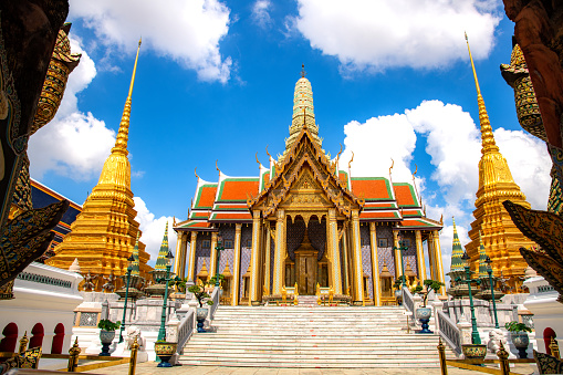 Beautiful building of Wat Phra Kaew Temple of the Emerald Buddha, grand palace on the cloudy blue sky day, the most famous spot and must visit place and temple in Bangkok, Thailand from the front door