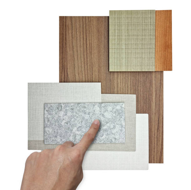 istock hand selecting to interior material board containing wooden veneers, fabric laminateds, grainy quartz stone, oak laminated, interior fabric wallpaper samples isolated on background with clipping path. 1393153223