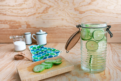 Homemade lemonade on a rustic wooden table.
Moisturizing cucumber water with lemon, served as organic as possible in a vintage kitchen. Horizontal photograph with space for text.