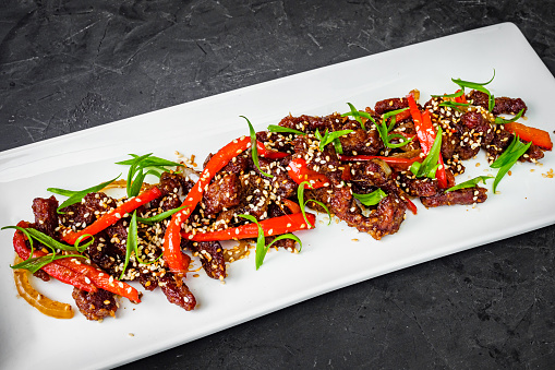 Sichuan roasted beef on a black background.