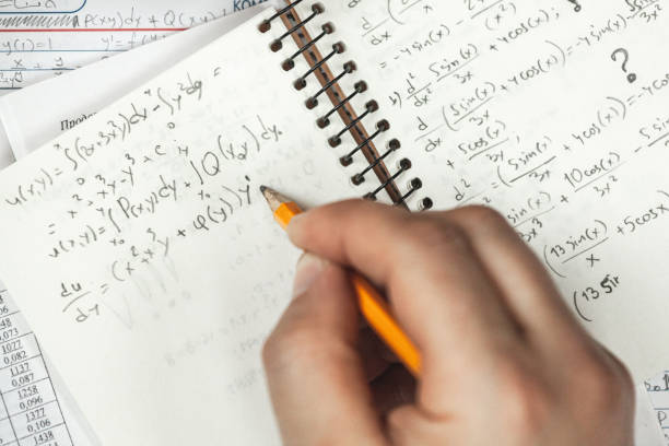 istock Math formulas are written in pencil in a notebook holding man in 1393153708