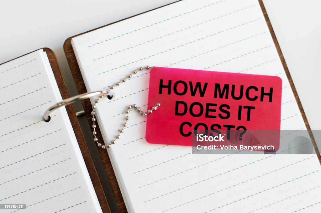 How much does it cost. business concept. Red card text on the background of an open notepad on the table Price Stock Photo