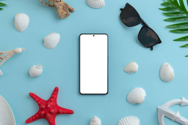 istock Phone mockup surrounded by shells, starfish, sunglasses, palm leaves on blue surface. Isolated screen for app design presentation. Summer travel composition. Top view, flat lay 1393155792