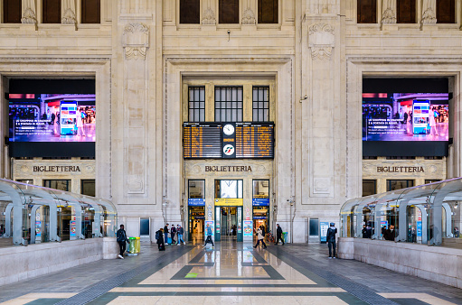 Milan, Italy - March 29, 2022: Front view of the arrivals and departures board in the monumental Galleria delle Carrozze (Carriages Gallery) in Milano Centrale train station, inaugurated in 1931.