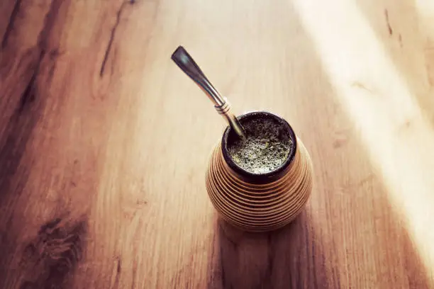 Healthy infused drink, energy boosting beverage on neutral wooden table.