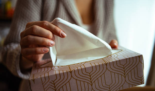 an anonymous woman taking paper tissue out of box - tissue box flu virus kleenex imagens e fotografias de stock