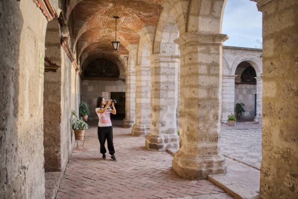 아레키파에있는 산타 카탈리나 수도원의 초보자 회랑을 촬영하는 라틴 관광객 - peru arequipa monastery convent 뉴스 사진 이미지
