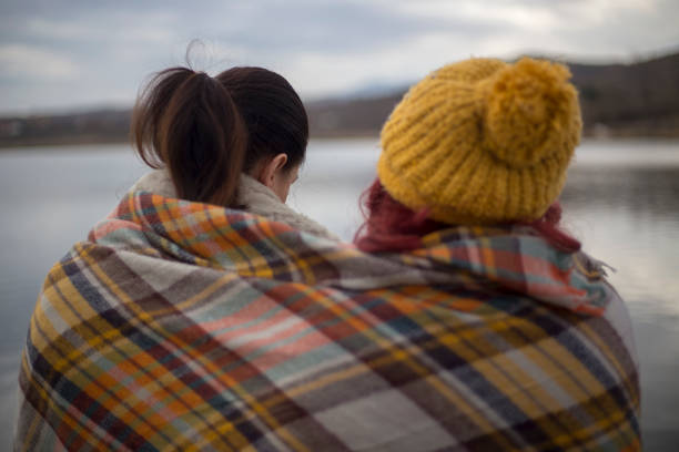 Young females sitting on the pier and talking
