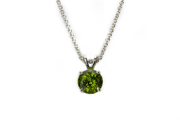 Peridot pendant, silver chain. White background. stock photo