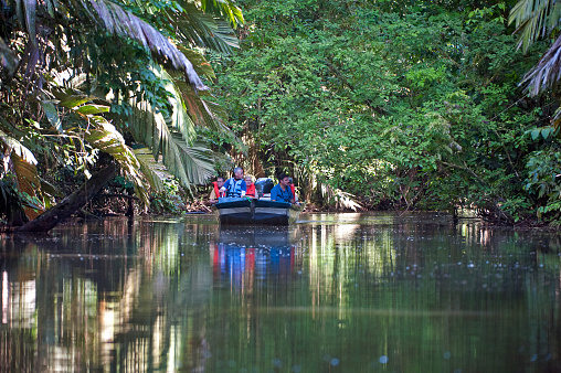 Tourists cruise the canals of Tortuguero, Caribbean coast, Costa Rica. Costa Rica is the central American country north of Panama that is renowned for its tropical birdlife, exotic wildlife and adventure pursuits such as wildlife spotting from small boats in the backwaters of the Caribbean coast.