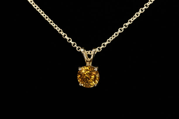 istock Gold Zircon pendant, silver chain. Black background. 1393164476