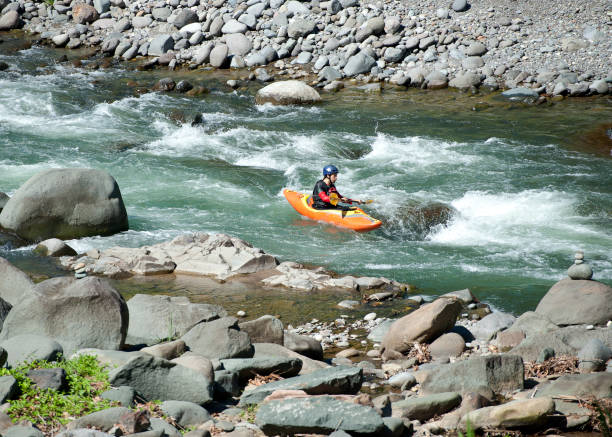 Kayaker navigates Class 3 rapids in rocky gorge, Pacuare River, Costa Rica. Costa Rica is the central American country north of Panama that is renowned for its tropical birdlife, exotic wildlife and adventure pursuits such as whitewater rafting, parasailing and ziplining