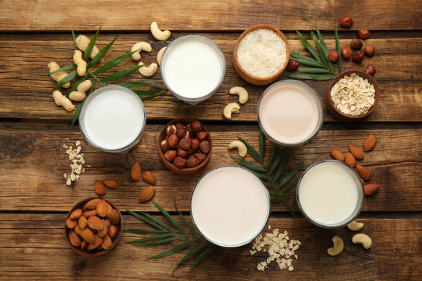 istock Different vegan milks and ingredients on wooden table, flat lay 1393164978
