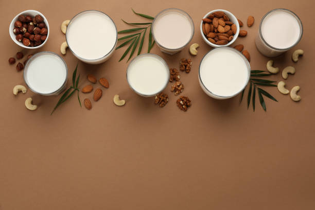 istock Different vegan milks and nuts on brown background, flat lay. Space for text 1393165713