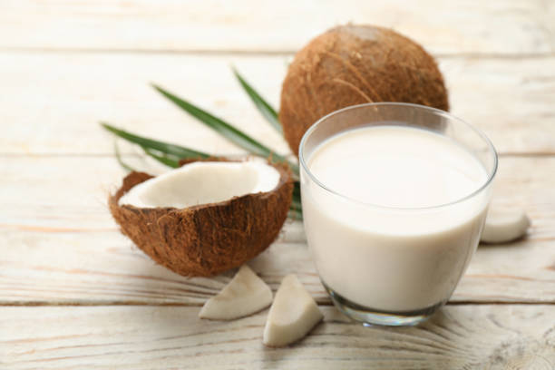 istock Delicious vegan milk and coconuts on white wooden table, closeup 1393165830