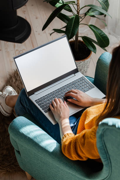 Young woman using laptop screen blank, mock up, work home