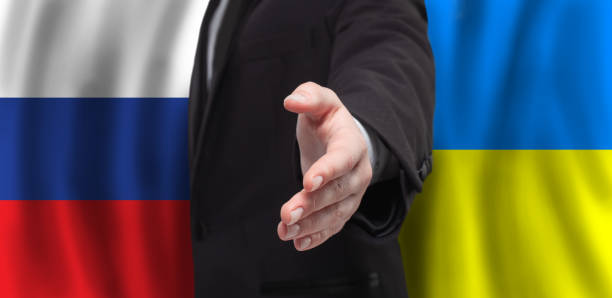 istock Open hand on flags of Ukraine and Russia background. Peace talks concept 1393167577