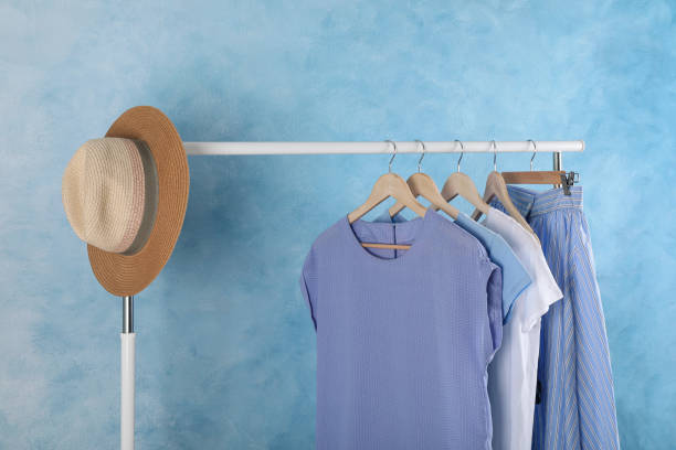 istock Rack with stylish clothes near light blue wall indoors 1393167689