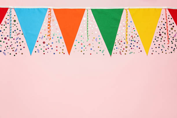 istock Bunting with colorful triangular flags and other festive decor on pink background, flat lay. Space for text 1393168738