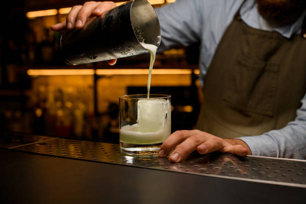 istock process of making a cocktail - pouring a drink from a shaker into a glass 1393168894