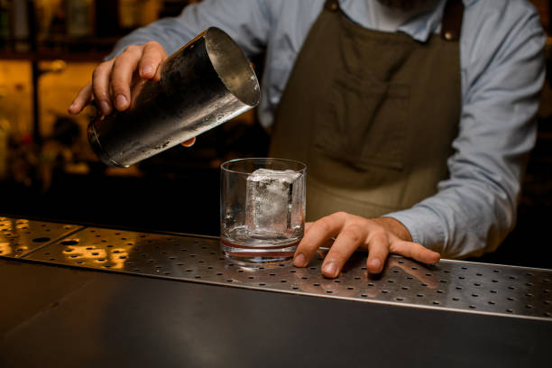 istock glass with an ice cube stands on the bar and shaker cup above it 1393168921