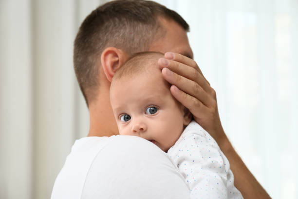 istock Father holding his cute baby on blurred background 1393168981