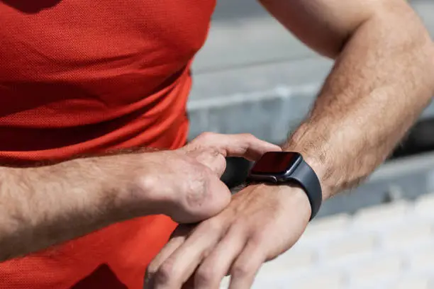 Closeup of a hand amputee athlete checking his workout progress on a smart watch - iWatch. Athlete with a hand disability. Hand amputee athlete motivated and healthy.