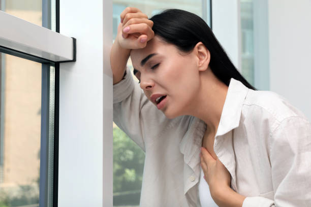 jeune femme souffrant de problèmes respiratoires près de la fenêtre à l’intérieur - peu profond photos et images de collection