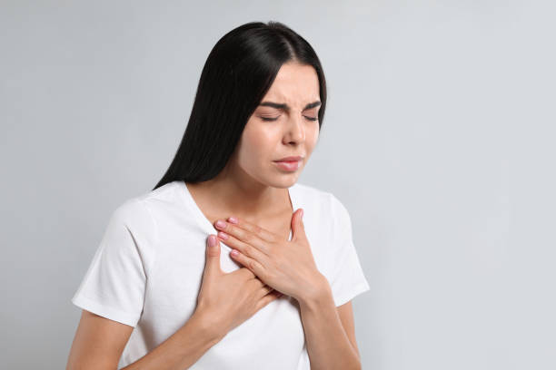 istock Young woman suffering from breathing problem on light background 1393170858