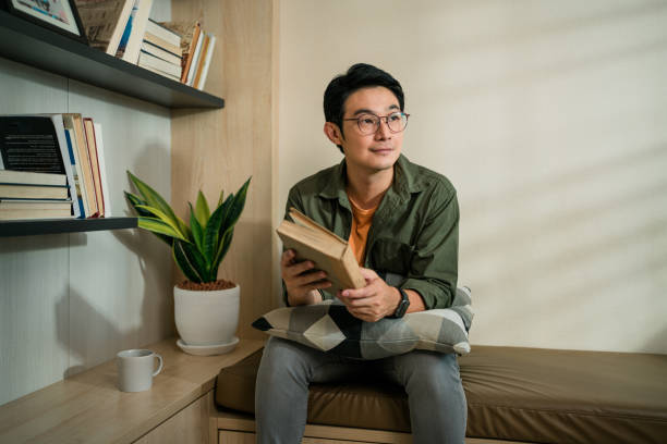 istock Man reading a  fiction book as hobby at home in the week end 1393171599