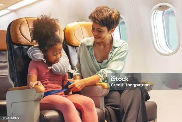 The Childs Safety Belt Is Being Fastened By Mom Stock Photo - Download Image Now - Airplane, Child, Sitting
