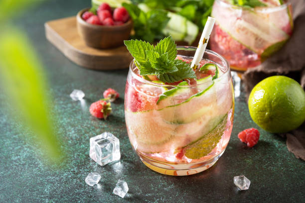 istock Soft drinks, healthy beverage, slimming water. Refreshing detox drinks made from organic raspberries, cucumbers, lime and mint leaves on a stone table. 1393173864