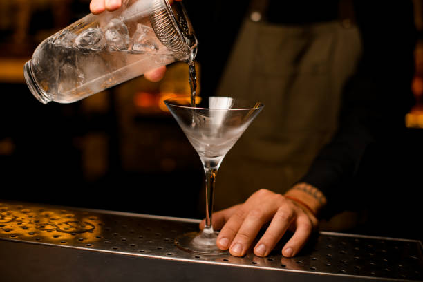istock martini glass on in which a cocktail is poured from a mixing cup 1393174083