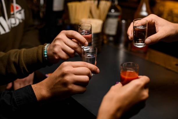 멕시코 데킬라 샷과 토마토 주스로 토스트하는 네 명의 젊은 사람들 - tequila shot 뉴스 사진 이미지