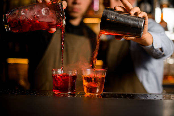 istock Two bartenders hold a shaker and a jug in their hands 1393176060