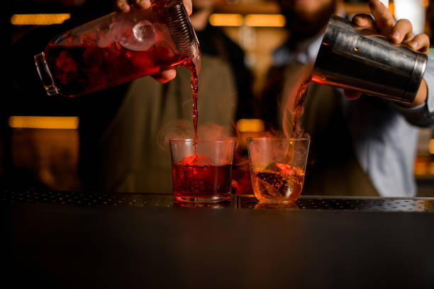 istock Two bartenders pouring red and brown alcoholic drinks from a shaker and a jug 1393176133