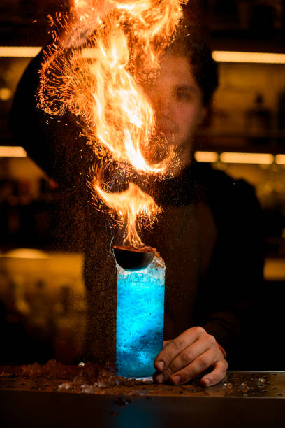 istock bartender sprinkling fired up blue alcohol drink with feijoa and ice 1393176428
