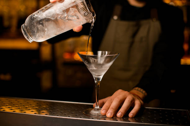 istock bartender professionally pours martini cocktail to glass with ice 1393177305