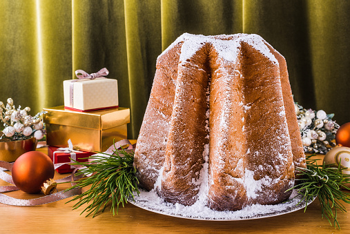 Pandoro Italian Christmas sweet bread with icing sugar on festive table.