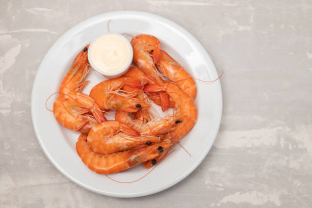 istock Boiled fresh shrimps with sauce in small bowl on white plate on ceramic 1393197759