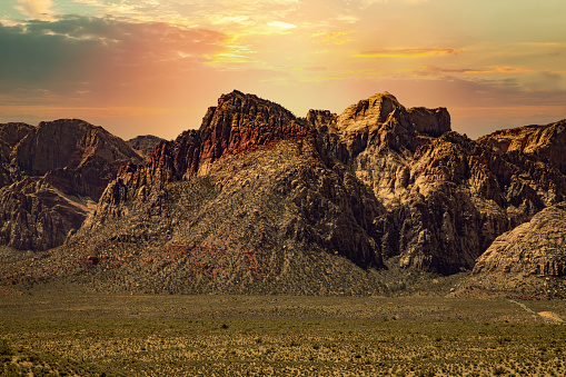 Horizontal color image of a mountainous landscape in Red Rock Canyon National Conservation Area, under a colorful sky.