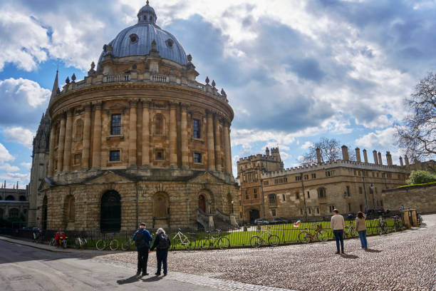 Radcliffe camera, bodleian library with tourists Oxford, UK - April 13, 2021: tourists in radcliffe Camera, bodleian library, oxford university, oxford, Oxfordshire, England, United Kingdom radcliffe camera stock pictures, royalty-free photos & images