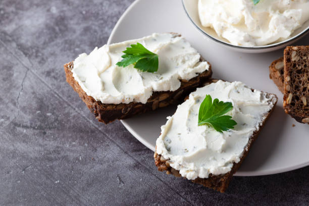 istock Rye bread with cream cheese on grey table. Whole grain rye bread with seeds 1393206223