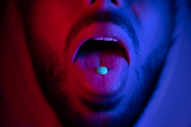 Close up of man mouth swallowing ecstasy drugs. Man taking MDMA ecstasy pill. Close up of man mouth swallowing ecstasy drugs. Man taking MDMA ecstasy pill. High quality 4k footage narcotic stock pictures, royalty-free photos & images