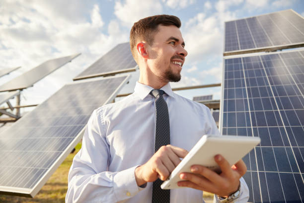 istock Cheerful male entrepreneur browsing tablet on solar farm 1393223633