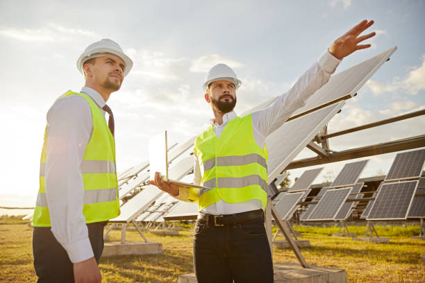istock Professional engineers inspecting solar panels in field 1393223676