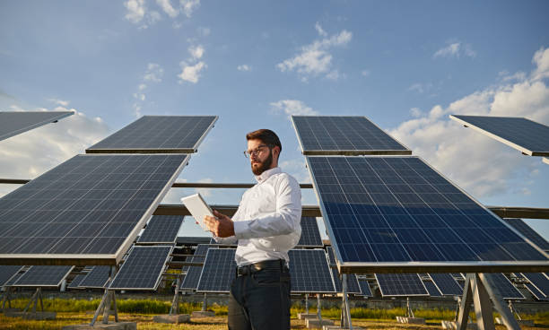 businessman using tablet near solar panels - solar panel solar power station solar energy solar equipment imagens e fotografias de stock