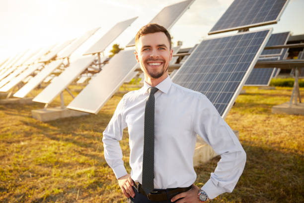 istock Cheerful businessman in field with solar batteries 1393223690