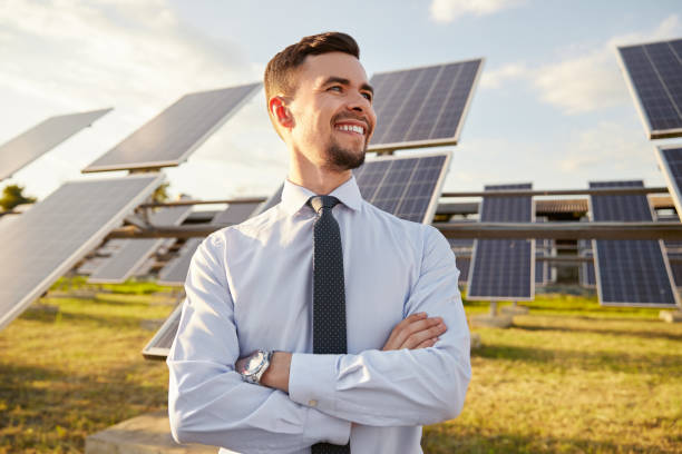 Confident businessman on solar power station stock photo